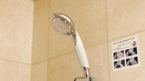 - Baño con ducha y pared en Hotel Nikko Northland Obihiro, en Obihiro