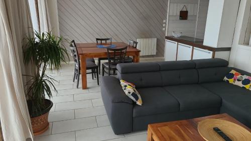 a living room with a couch and a table at Appartement Vue Mer, RDC, Plage de Trestrignel in Perros-Guirec