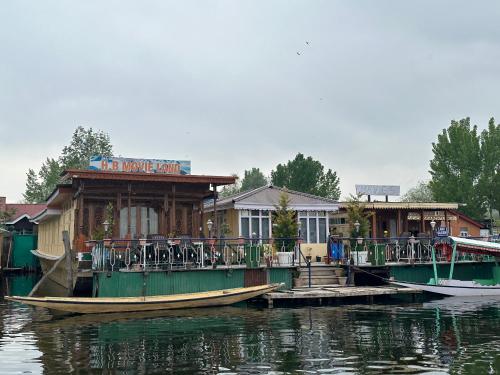 a building on a dock next to the water at Movie land group of house boats in Srinagar