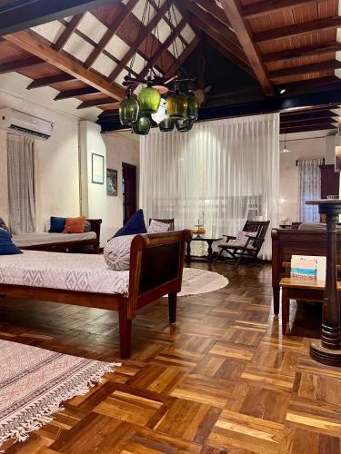 a bedroom with a bed and a living room with a piano at Svarna Heritage in Kalyānpur
