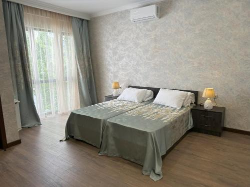 1 dormitorio con 1 cama grande y 2 almohadas en Three Palms House, en Tiflis