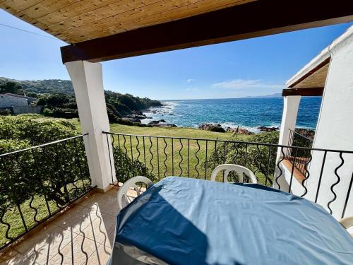 balcón con mesa y vistas al océano en Résidence Punta paliagi en Calcatoggio