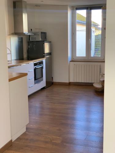 une cuisine avec des appareils blancs et un parquet dans l'établissement Appartement T2 en duplex à 5 minutes de Bayonne, à Boucau