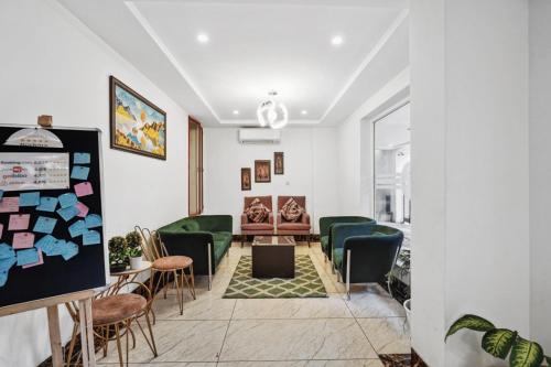 a waiting room with green chairs and a table at Amahi Inn I Signature Towers in Gurgaon