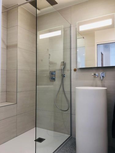 une salle de bain avec une douche avec une porte vitrée dans l'établissement T3 FRONT de mer dernier étage vue mer Petit havre de paix pour vos vacances Emplacement unique vue mer panoramique à 180 degrés pour ce T3 en face de la plage front de mer vue sur les iles 5 et dernier étage avec ascenseur, au Lavandou