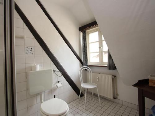 a white bathroom with a toilet and a window at Beautiful holiday apartment in Dorfmark in Dorfmark