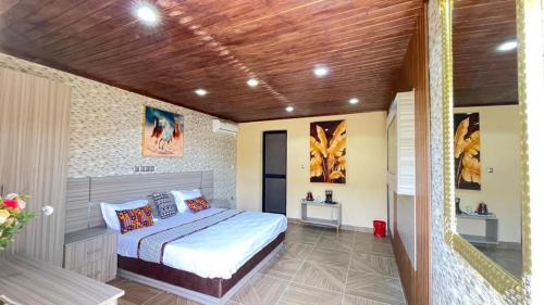 een slaapkamer met een bed en een houten plafond bij Hôtel bergmann in Ouro Sogui