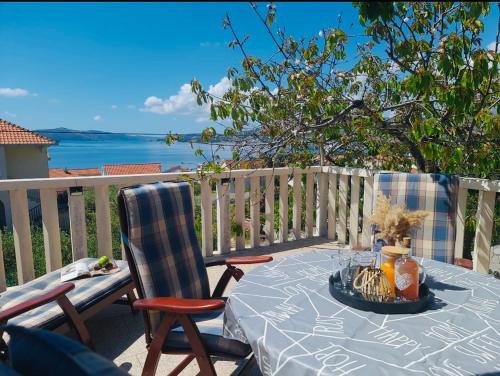 a table and chairs on a deck with a view of the ocean at Apartments Mia in Okrug Gornji