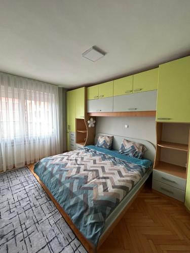 a bedroom with a large bed and yellow and green walls at TOP Center Apartment in Bitola