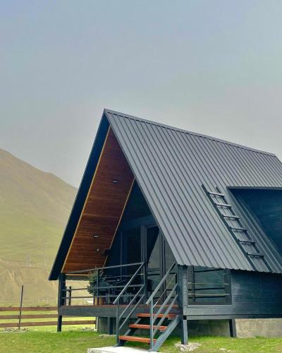 a large building with a metal roof and a staircase at Wildwood Kazbegi in Stepantsminda