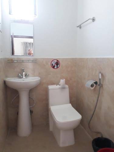 bagno con servizi igienici, lavandino e specchio di Dragon Hotel a Pokhara