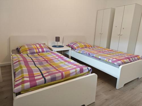 two beds sitting next to each other in a room at Work and stay IaM 90 qm 3 Schlafzimmer 6 betten mit Balkon und kraftraum in Plettenberg