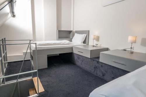 a white bedroom with a bed and two night stands at Haus Overbach in Barmen