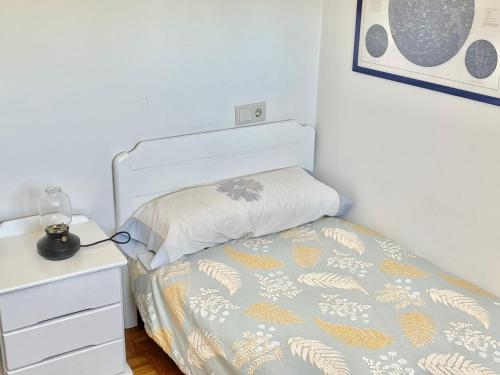 a small bedroom with a bed and a night stand at La Casa de los Libros in Muros de Nalón