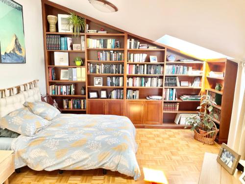 a bedroom with a bed and book shelves with books at La Casa de los Libros in Muros de Nalón