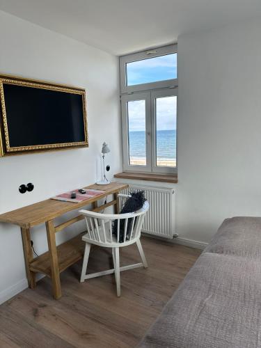 a bedroom with a desk and a tv and a bed at Strandhaus WOTAN in Kühlungsborn