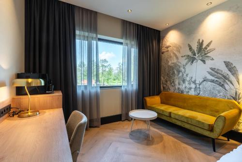 a living room with a yellow couch and a window at MyHotel Meppel in Meppel