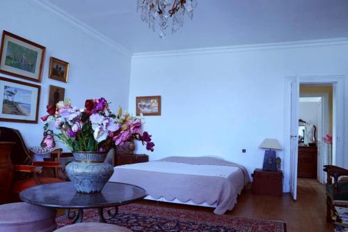 une chambre avec un lit et un vase de fleurs sur une table dans l'établissement Chambre d'hôtes chez Johannes et Adèle, à Brive-la-Gaillarde