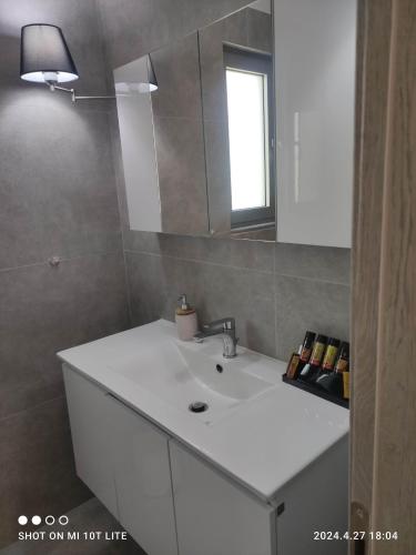 a bathroom with a white sink and a mirror at Molineux Luxury Nikiti in Nikiti