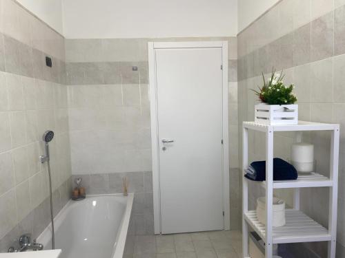 a bathroom with a white tub and a white shelf at Elegante & Moderno Loft in Centro Città in Seregno