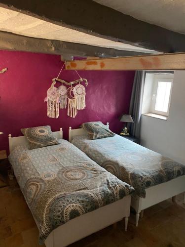 RoquestéronにあるLe PHoenixの紫の壁のベッドルーム1室(ベッド2台付)