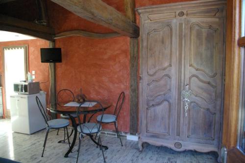 - une salle à manger avec une table, des chaises et une grande porte dans l'établissement la bergerie, à Laubressel