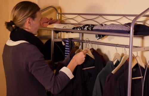 una mujer mirando la ropa en un estante en Appartamento Rosso Buoni e Cattivi, en Cagliari