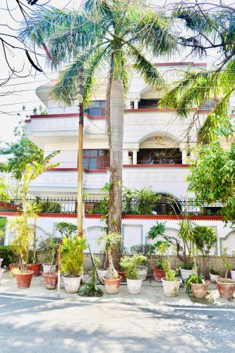 budynek z palmami przed nim w obiekcie Madhuraj Hotels w mieście Noida