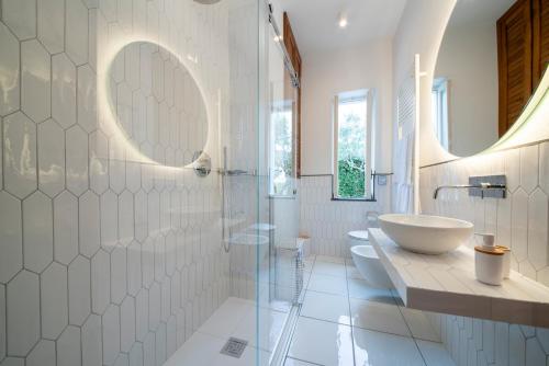 a white bathroom with a sink and a shower at Il Lauro Luxury Villa in Ischia