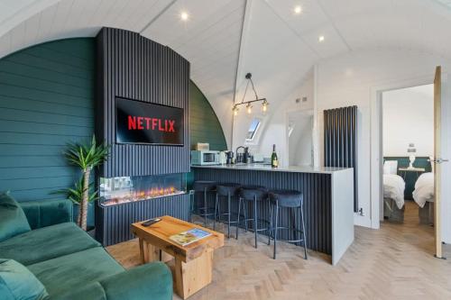 a living room with a couch and a kitchen at Nestledstays - The Barn House With Hot Tub in Arundel