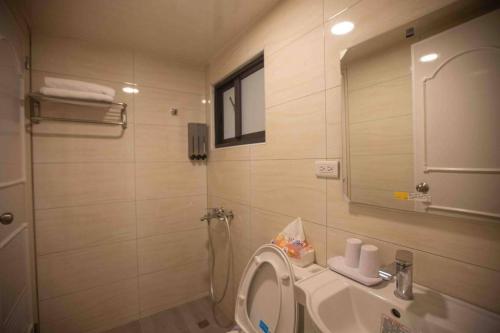 a bathroom with a sink and a toilet and a mirror at Xianwang Homestay in Jincheng
