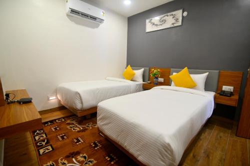 Carry Inn Hotel Indore في إندوري: غرفه فندقيه سريرين مع مخدات صفراء