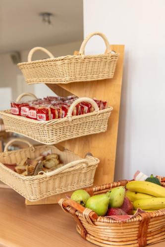 a group of baskets on a table with apples and bananas at Ageri Hotel in Tinos Town