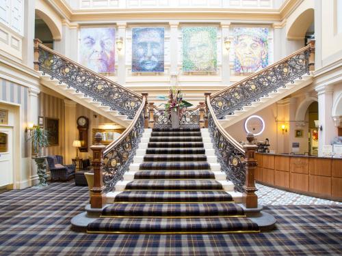 a stairway leading up to a large room with many windows at The Royal Highland Hotel in Inverness