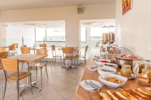um restaurante com uma mesa com comida em Ageri Hotel em Tinos Town