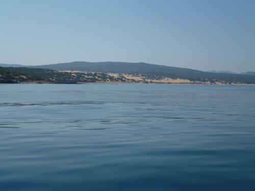 a large body of water with mountains in the background at Casa vacanze con terrazza panoramica vista mare in Portu Maga