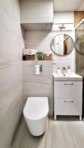 a bathroom with a white toilet and a sink at Przytulny Apartament - Centrum in Piaseczno