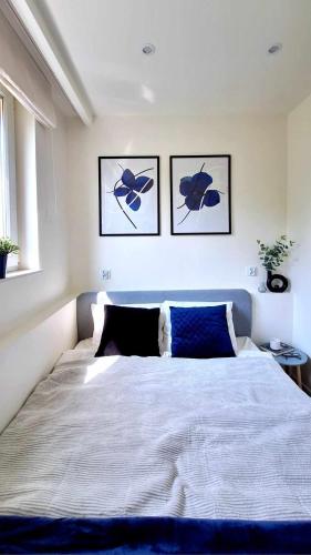 a bedroom with a large bed with three pictures on the wall at Przytulny Apartament - Centrum in Piaseczno