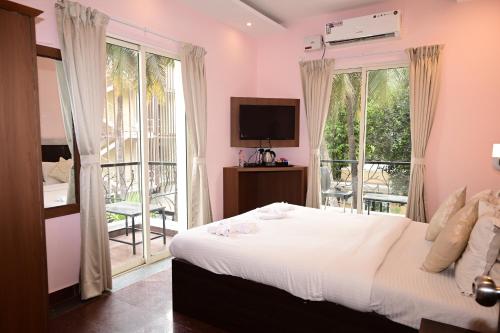 1 dormitorio con 1 cama grande y balcón en Blue Pearl A Boutique Hotel en Goa
