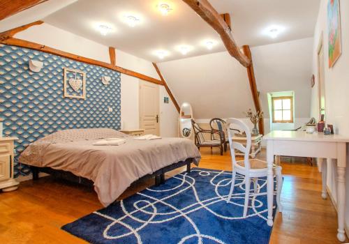 1 dormitorio con 1 cama, mesa y sillas en Aux Passiflores en Cempuis