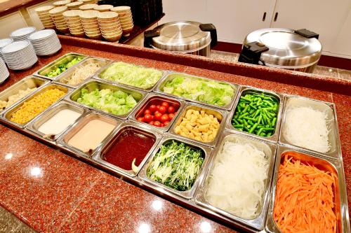 a counter with trays of vegetables and other ingredients at Yonago Universal Hotel in Yonago