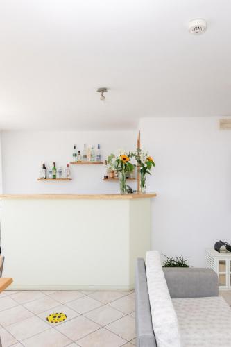 a white living room with a couch and a counter at Ageri Hotel in Tinos Town