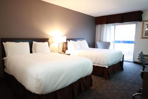 Un pat sau paturi într-o cameră la Days Inn by Wyndham Sudbury & Conference Centre