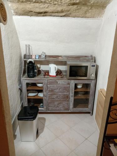 - une petite cuisine avec un four micro-ondes dans l'établissement Studio troglodyte en Provence, à Cornillon-Confoux