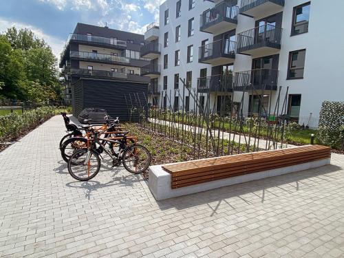 dwa rowery zaparkowane obok ławki przed budynkiem w obiekcie BlueHouse Apartment Warsaw w Warszawie