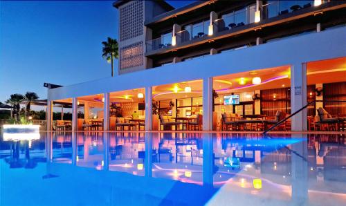 a hotel with a swimming pool at night at Sveltos Hotel in Larnaca