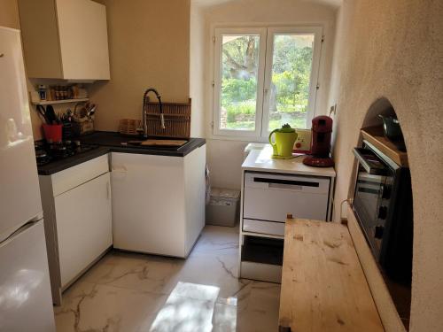 una pequeña cocina con electrodomésticos blancos y una ventana en tour casella, en Bonifacio