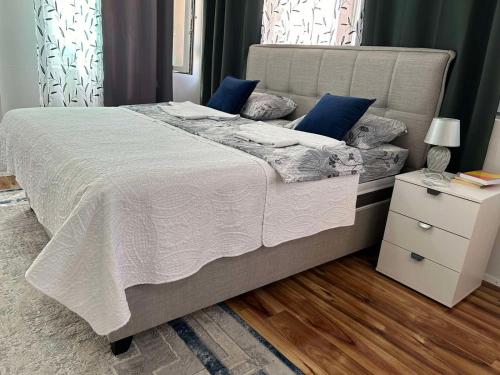 a bedroom with a large bed with blue pillows at Apartman Glorija in Kotor