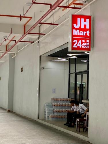 two men sitting inside of a building with a sign at The Podium-Studio-Free 1 Parking-6 Pax-D321B in Kuching