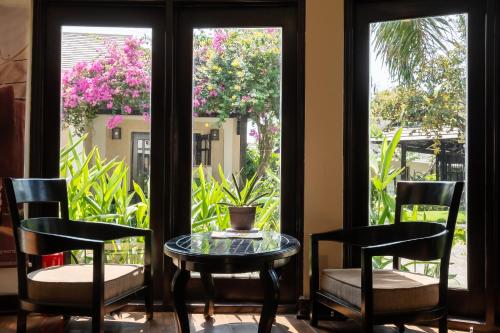 a table and chairs in front of a window at Anja Beach Resort & Spa in Phu Quoc